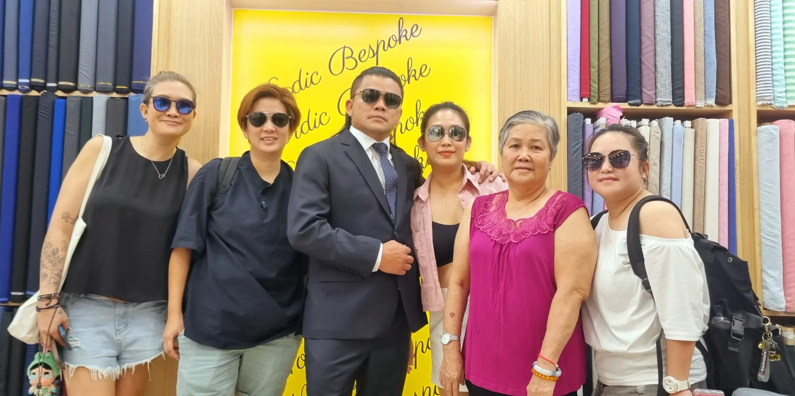 Happy customers posing inside Nordic Bespoke Tailor showroom