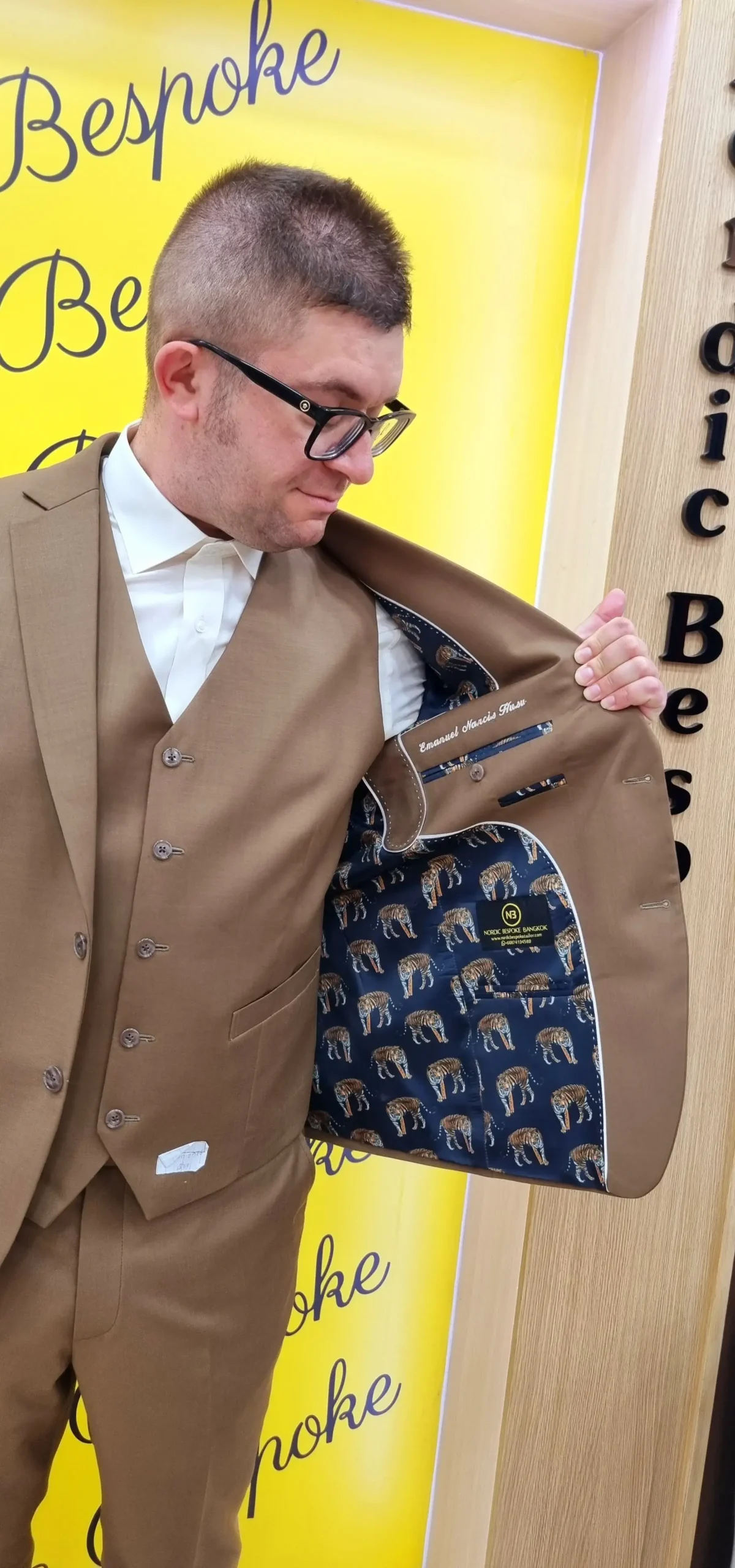 Customer showing the patterned lining of a brown suit jacket